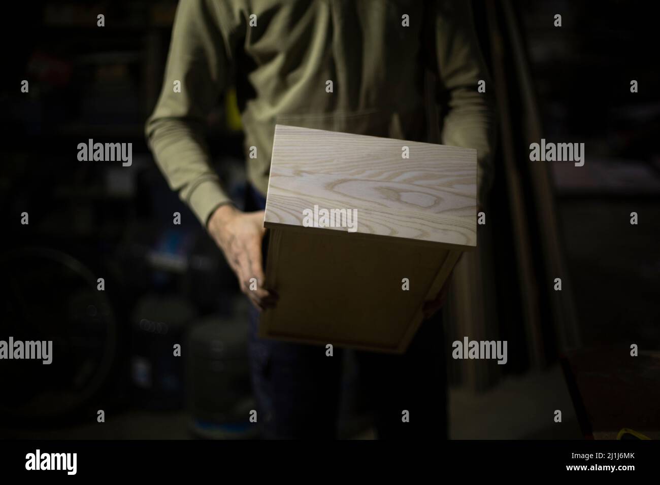 Scatola di legno in mano. Produzione di mobili da tavole. armadio in legno. Dettagli del lavoro. Risultato dell'elaborazione della scheda. Foto Stock