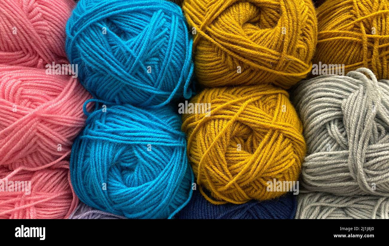 Filo di lana blu, giallo e rosa. Matasse multicolore di lana primo piano Foto Stock