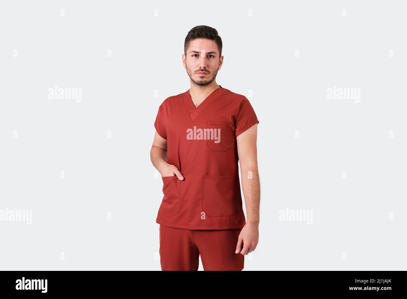 Ritratto di un medico o infermiere maschio che indossa uniforme medica borgogna. Foto di alta qualità Foto Stock
