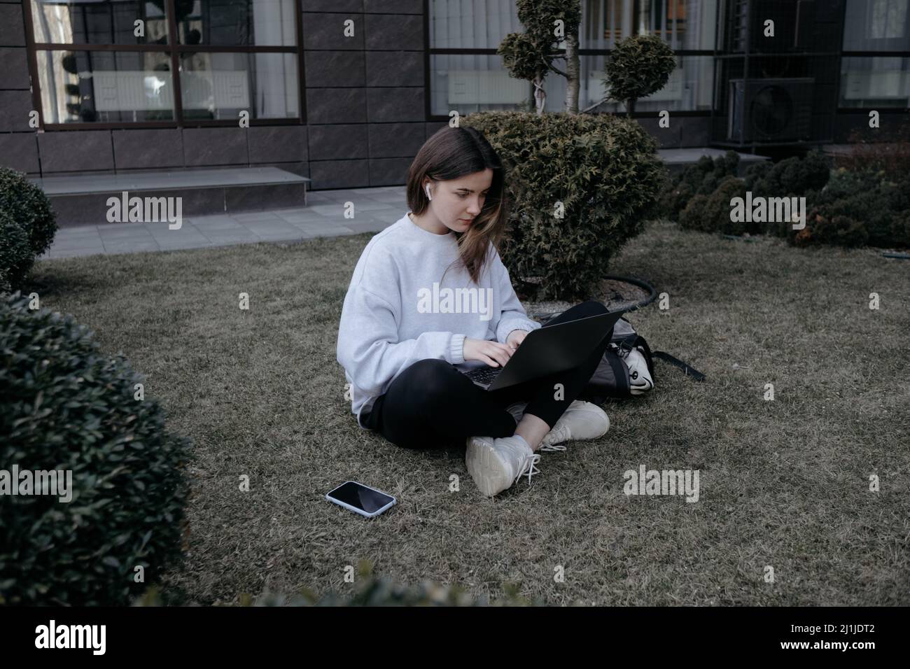 Lavoro all'aperto. Donna che lavora su un notebook nel parco. Lavoro remoto lontano durante la quarantena coronavirus covid-19. Foto Stock