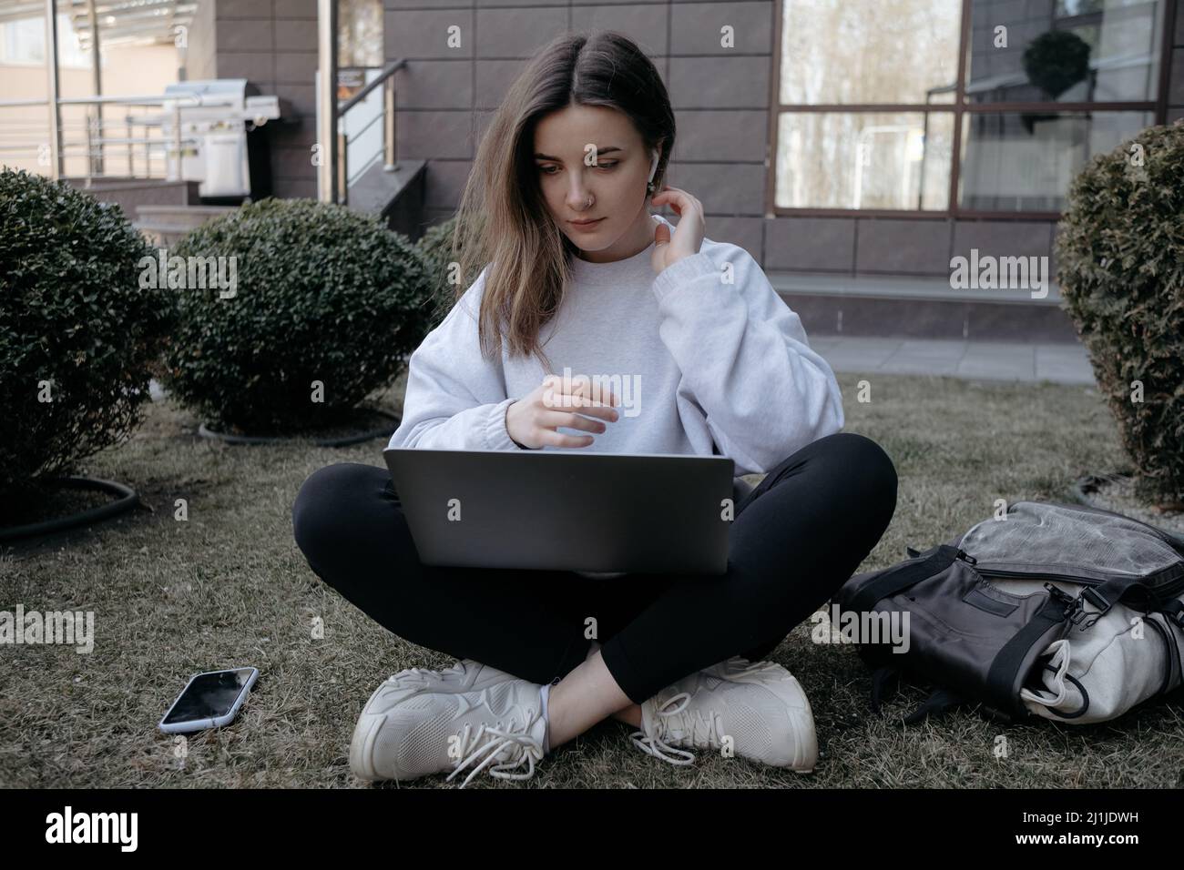 Lavoro all'aperto. Donna che lavora su un notebook nel parco. Lavoro remoto lontano durante la quarantena coronavirus covid-19. Foto Stock
