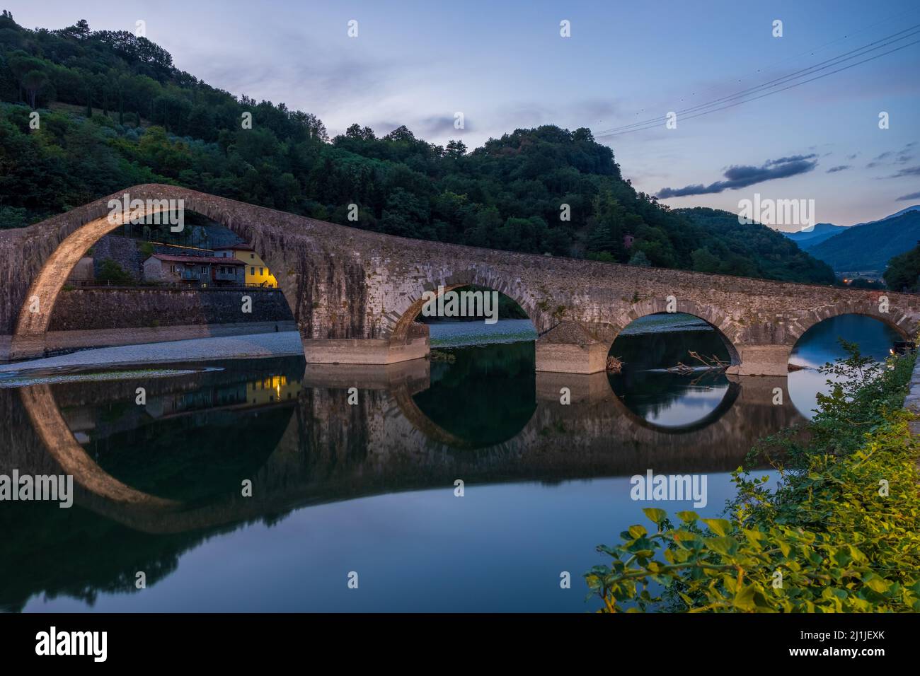 Ponte del Diavolo durante l'ora Blu di una giornata estiva, bellissimo ponte in una valle toscana a Lucca. Foto Stock