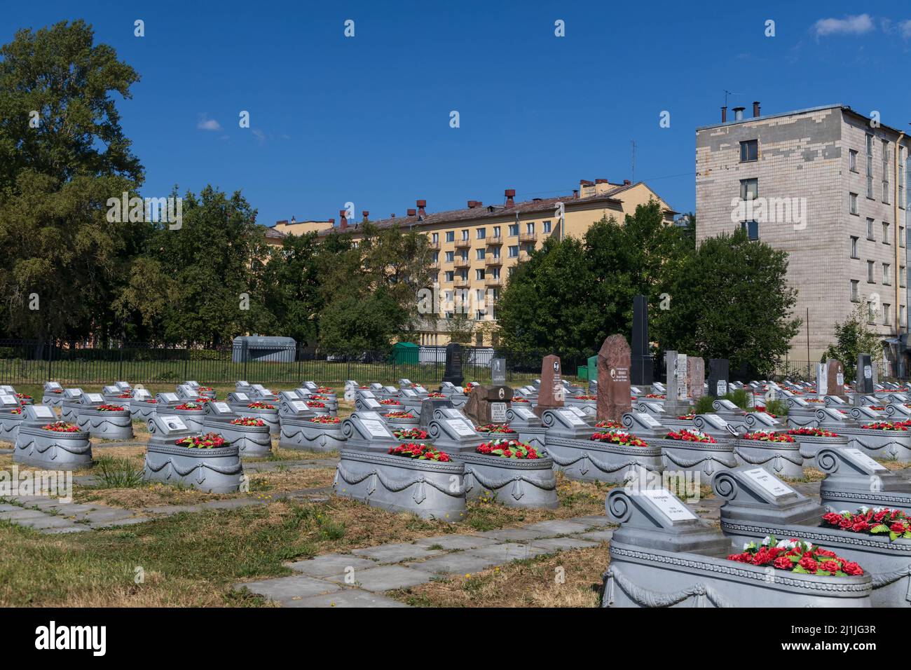 San Pietroburgo, Russia - 18 luglio 2021: Cimitero commemorativo militare della seconda guerra mondiale durante l'assedio di Leningrado vicino a edifici residenziali Foto Stock