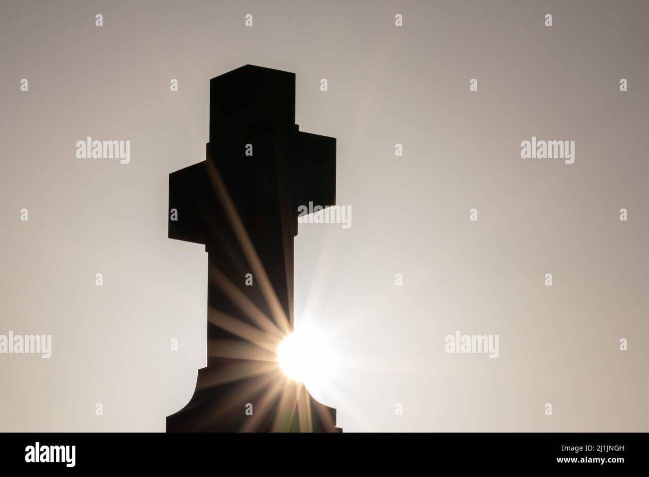 La silhouette a croce luminosa con raggi del sole luce del tramonto e cielo sereno della sera mostra la spiritualità del cristianesimo della chiesa e il perdono nel cimitero Foto Stock