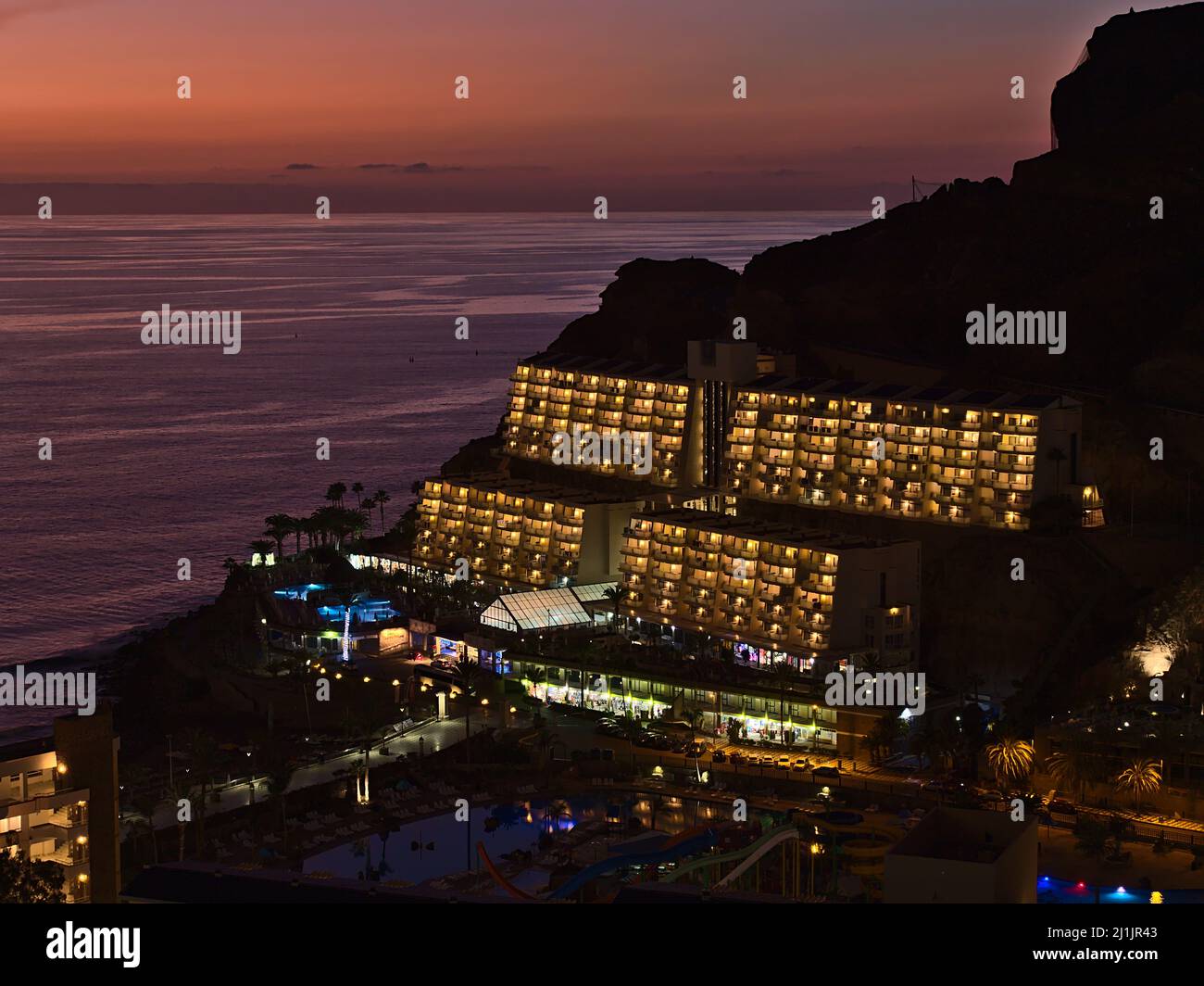 Vista aerea del resort turistico Taurito, Gran Canaria meridionale, Isole Canarie, Spagna in serata dopo il tramonto con il cielo colorato e l'hotel illuminato. Foto Stock