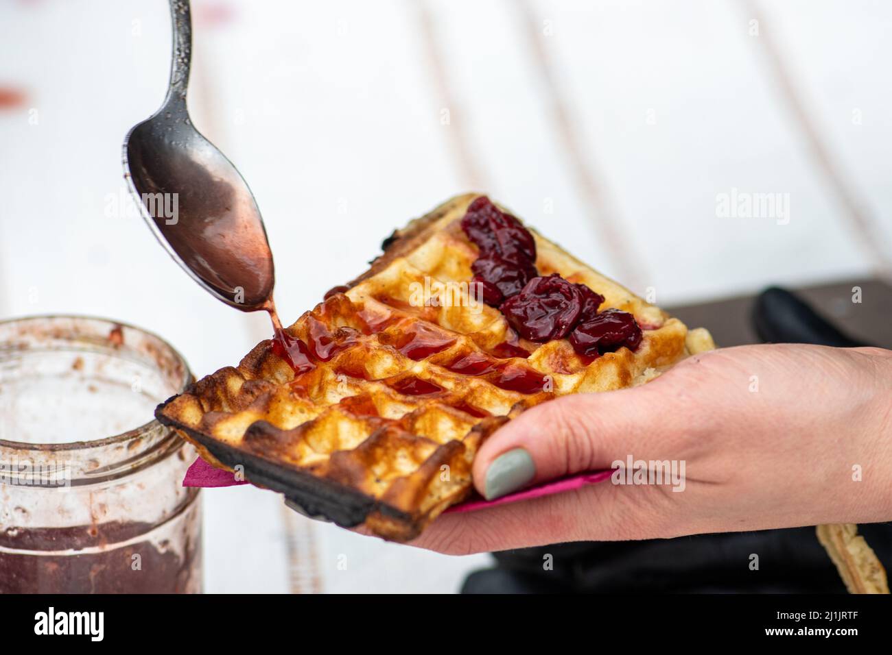 Preparazione di waffle o cialde con marmellata, piatto a base di impasto lievitato o cotto tra due piatti a motivi geometrici Foto Stock