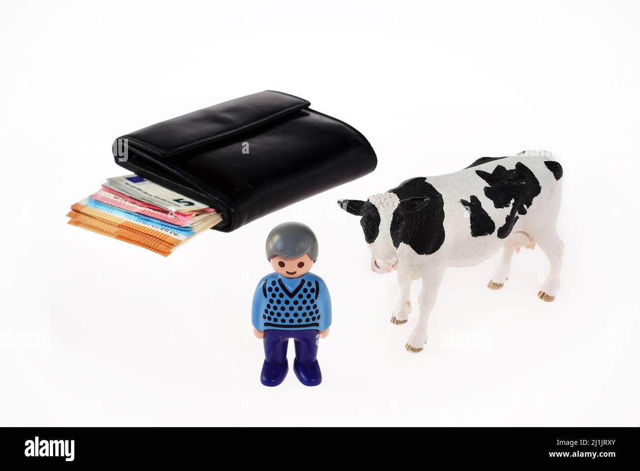 Una mucca, un contadino e un portafoglio Foto Stock