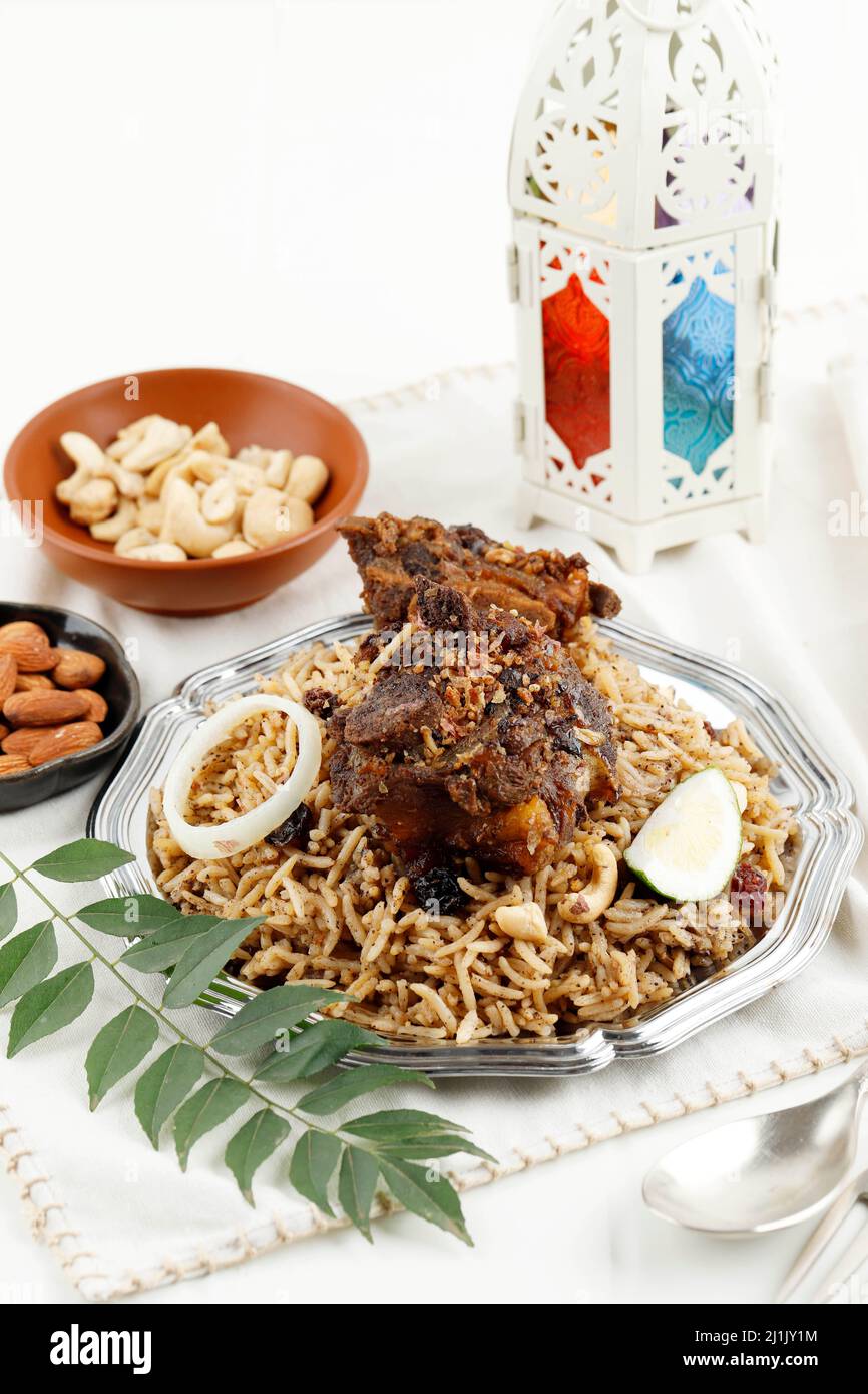 Fuoco selettivo Un piatto di riso di Agnello Kebuli Kabli servito con Acar, Raisin, e Cashew per Ifthar Ramadan Foto Stock