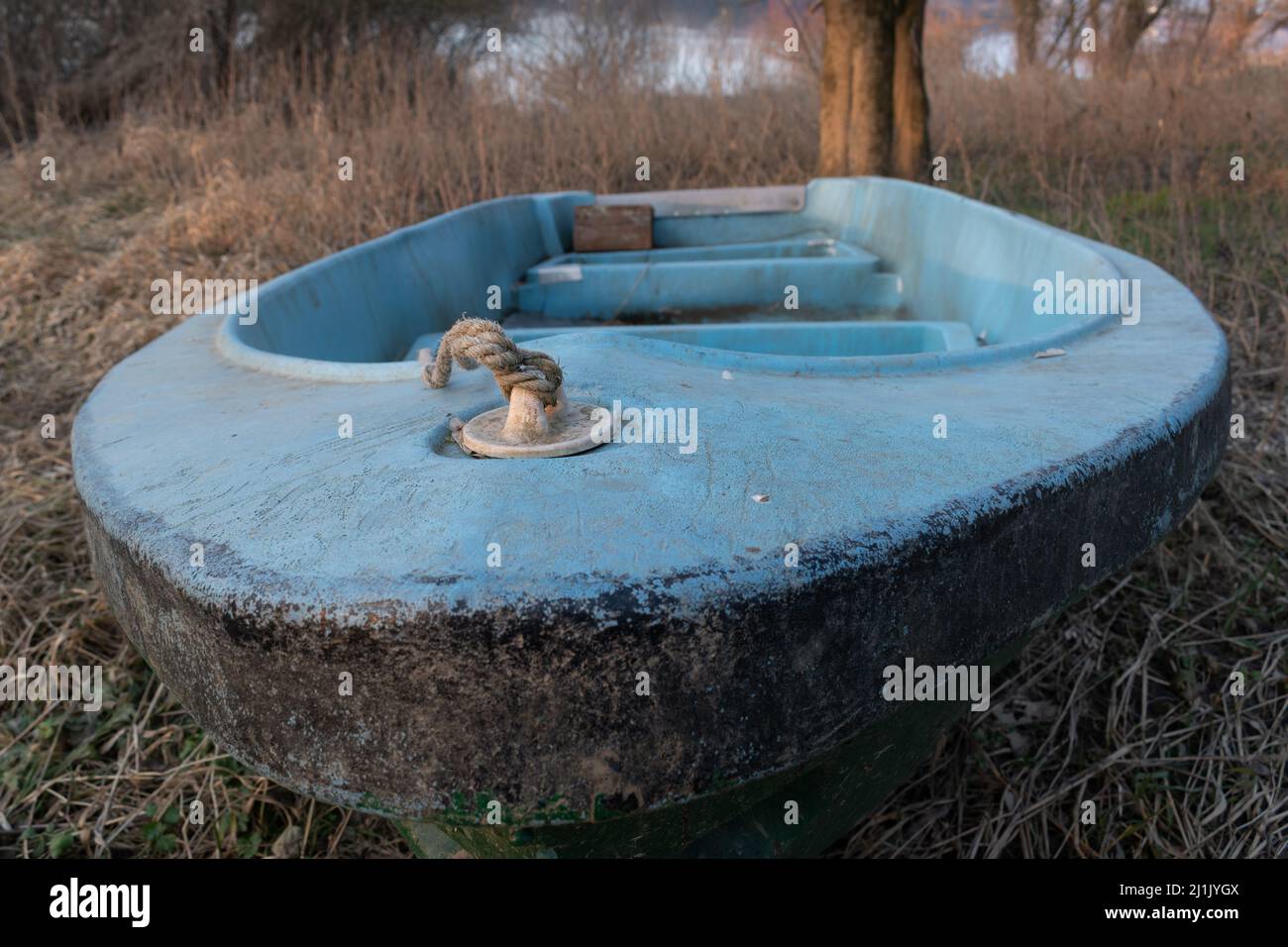 Nodo di corda sulla prua della vecchia barca con cracked blu vernice a terra in fuoco selettivo Foto Stock