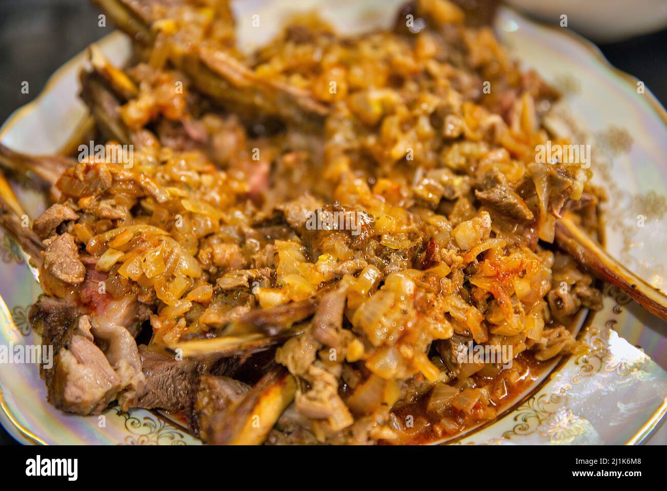 Un piatto di montone cotto al forno con cipolle closeup Foto Stock