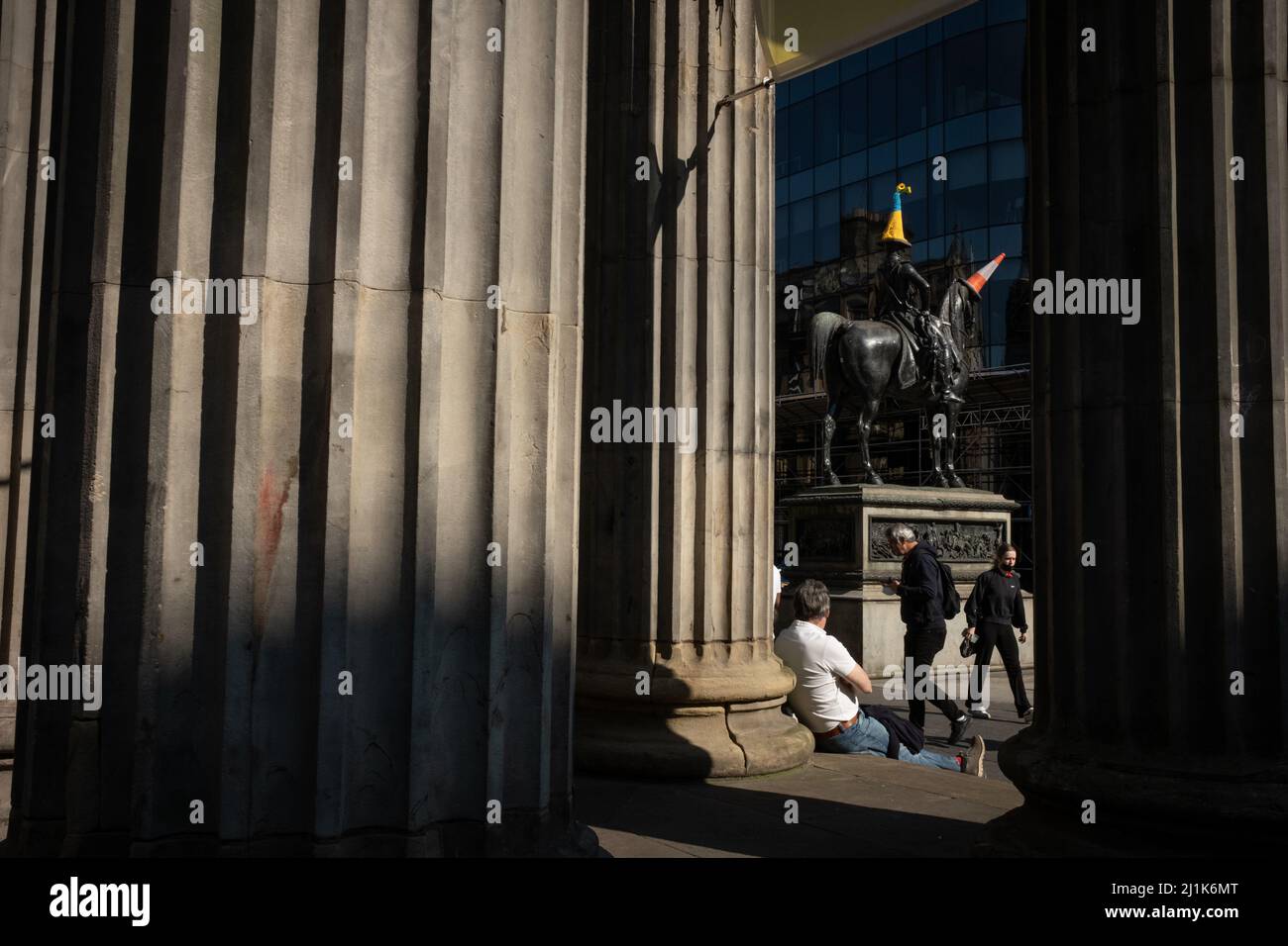 Glasgow, Regno Unito. 26th marzo 2022. Statua del Duca di Wellington in Queen Street con un cappello a cono di polizia a tema bandiera Ucraina blu e giallo, come accovacciato da Pauline McWhirter, a sostegno dell'Ucraina nella loro attuale guerra con il presidente PutinÕs Russia, a Glasgow, Regno Unito. 26 marzo 2022. Photo credit: Jeremy Sutton-Hibbert/ Alamy Live News. Foto Stock