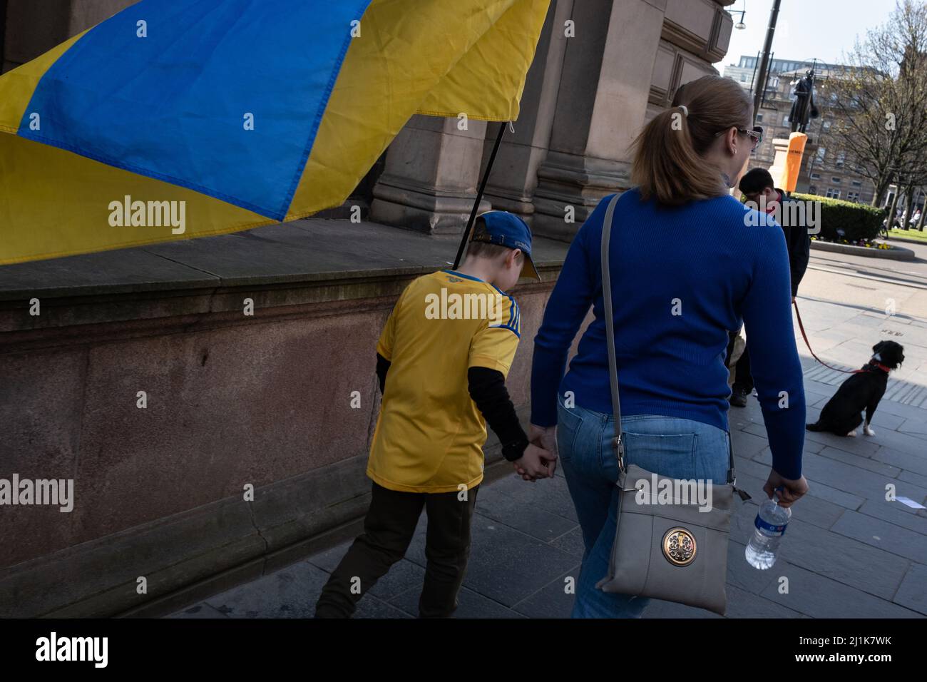 Glasgow, Scozia, 26th marzo 2022. Una famiglia Ucraina, con bandiere blu e gialle ucraine, si recheranno a George Square per il raduno Stand with Ukraine a sostegno del loro paese nella sua attuale guerra contro l'invasione del presidente PutinÕs Russia, a Glasgow, Scozia, 26 marzo 2022. Photo credit: Jeremy Sutton-Hibbert/Alamy Live News. Foto Stock