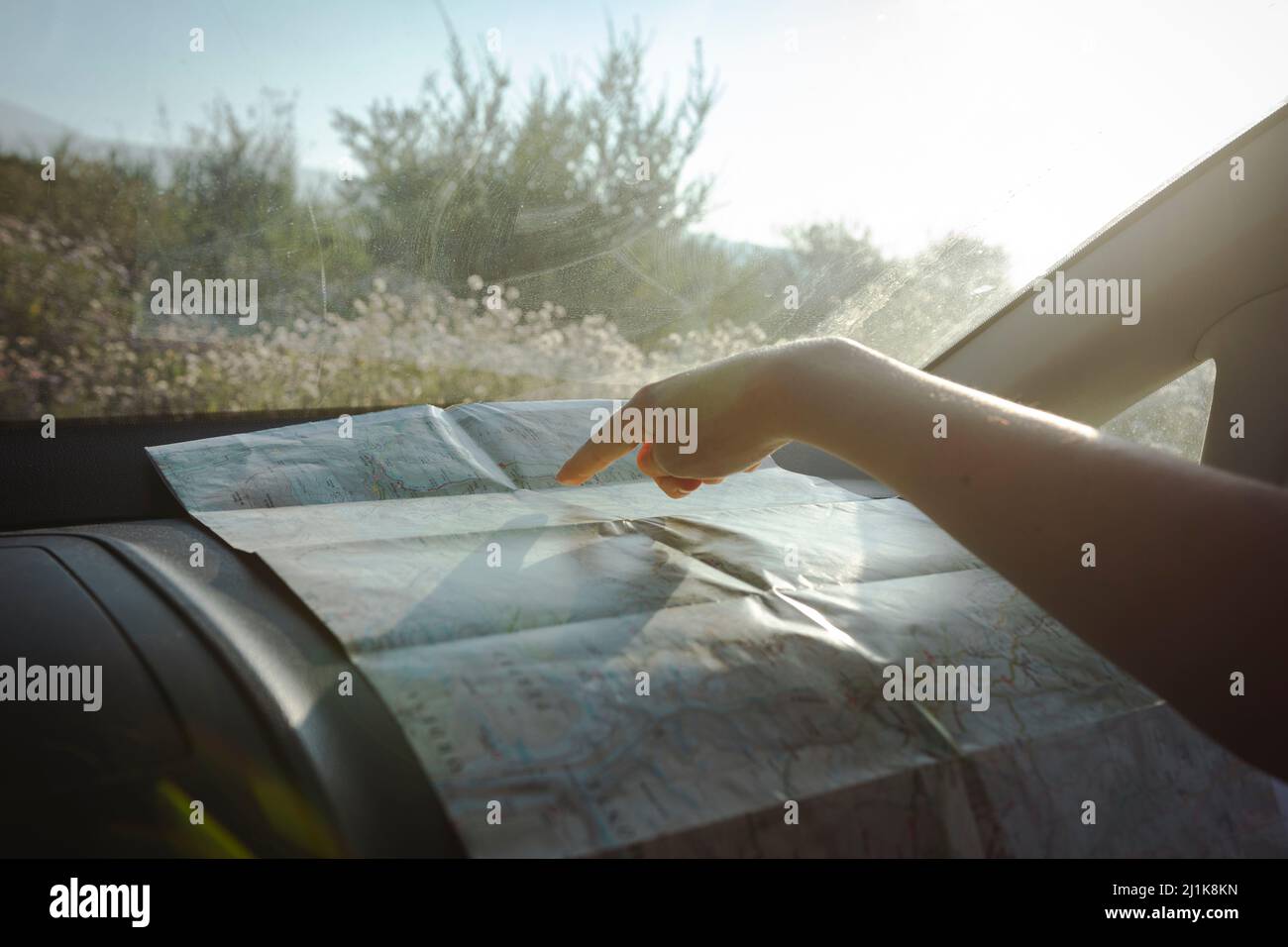 Ragazza che guarda e indica una mappa durante un viaggio su strada Foto Stock