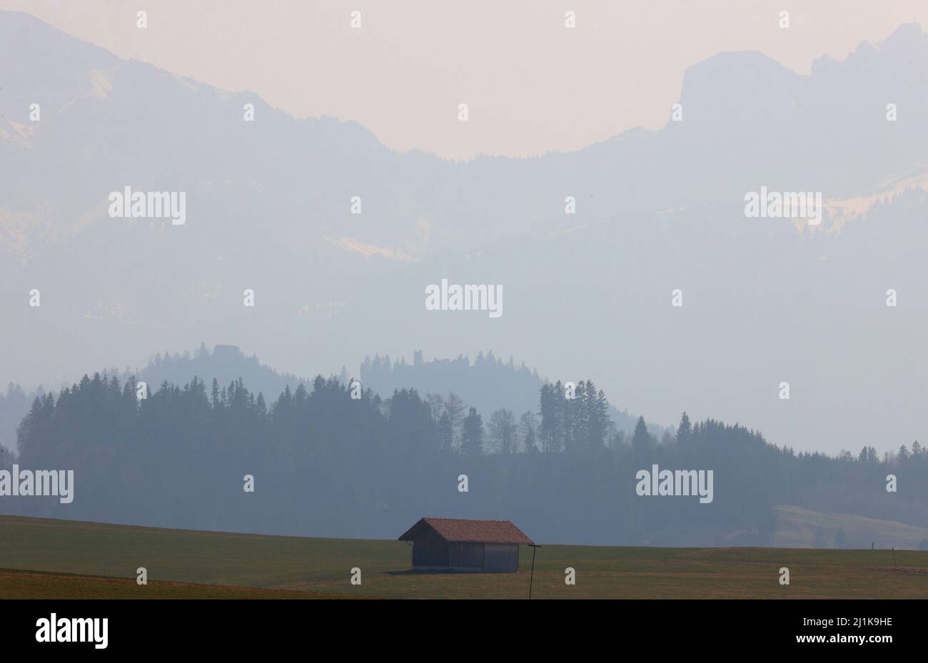 Pfronten, Germania. 26th Mar 2022. I contorni delle rovine del castello Eisenberg (l) e Hohenfreyberg si distinguono al sole contro il panorama delle Alpi. Credit: Karl-Josef Hildenbrand/dpa/Alamy Live News Foto Stock