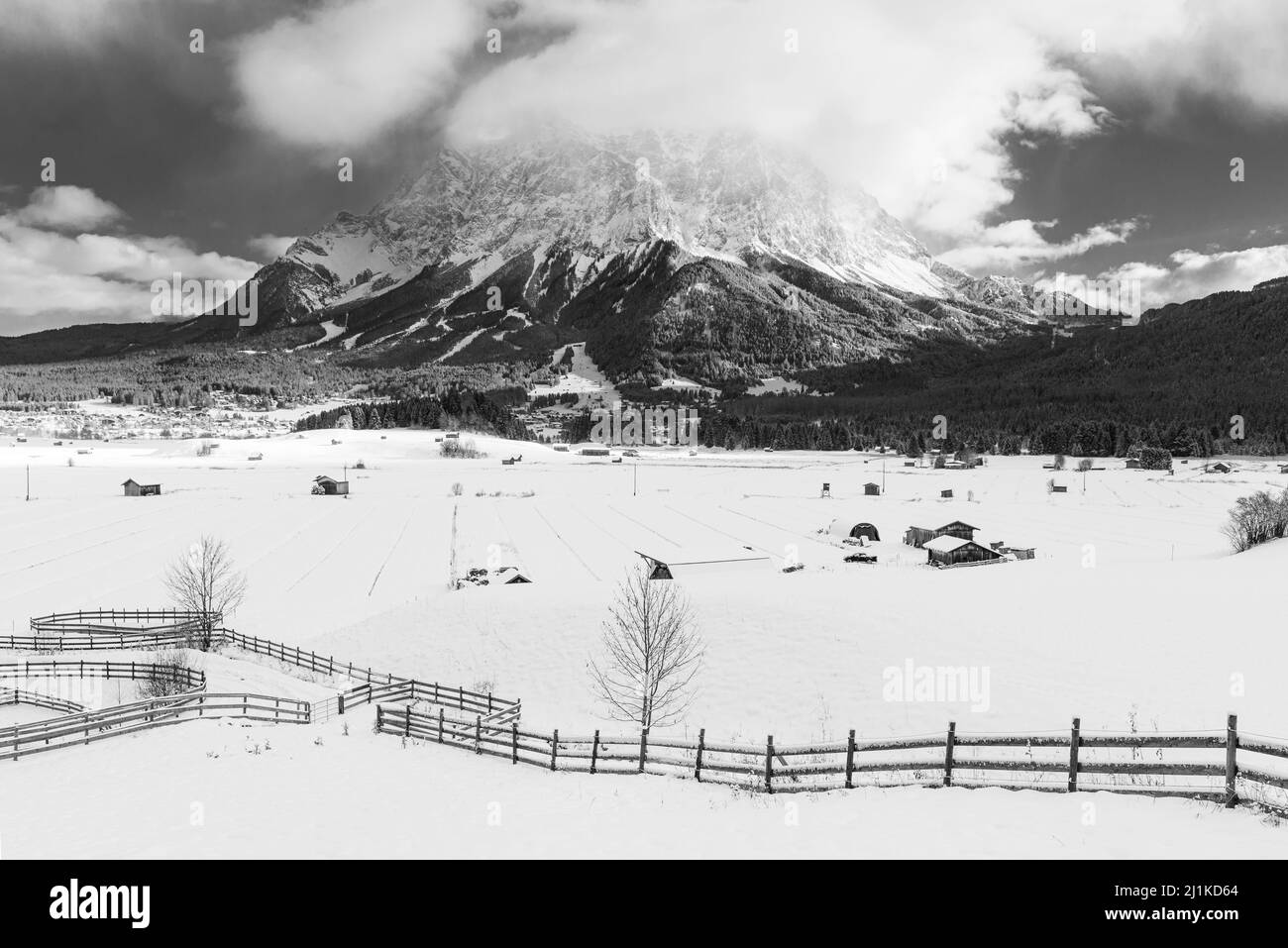 Il massiccio del Wetterstein con le Zugspitze sopra il bacino innevato di Ehrwald al sole del mattino in inverno, Tirolo, Austria Foto Stock