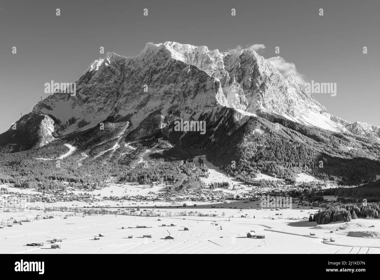 Il massiccio del Wetterstein con le Zugspitze sopra il bacino innevato di Ehrwald al sole del mattino in inverno, Tirolo, Austria Foto Stock