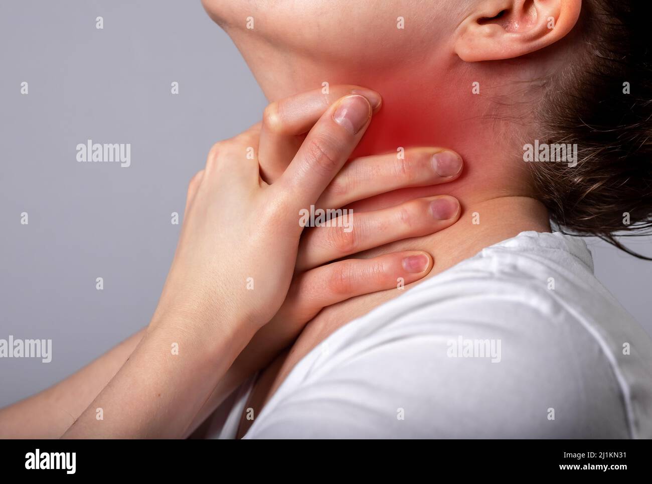 Attacco di asma. Donna soffocante, respirante pesantemente. Mal di gola. Mani che tengono il collo con punto rosso primo piano. Malattie respiratorie, concetto di medicina. Foto di alta qualità Foto Stock