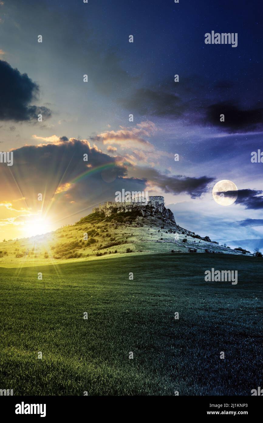 concetto di cambiamento di giorno e di notte sopra il castello sulla collina. paesaggio fantasy composito. prato erboso in primo piano. cime rocciose della cresta Foto Stock