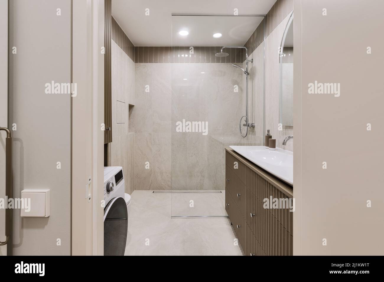 Moderno design minimalista degli interni del bagno con piastrelle in marmo e mobili in cachi Foto Stock
