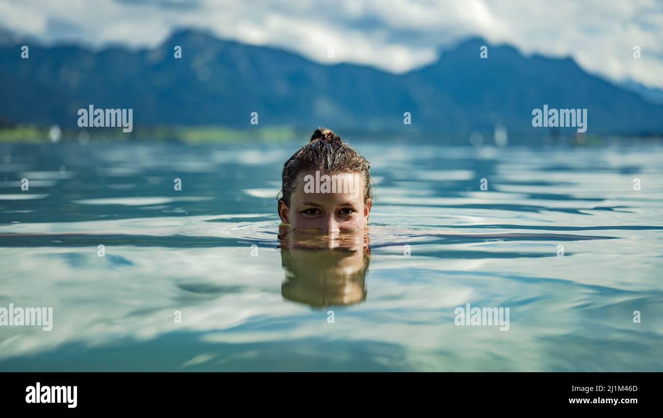 Donna che gode il bagno al lago Forggensee Foto Stock