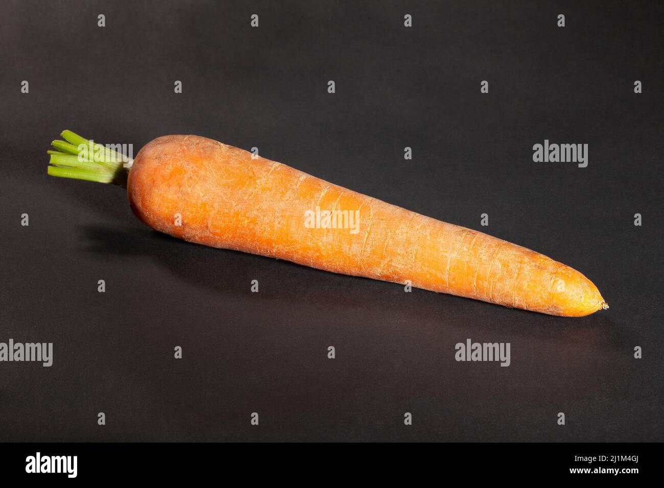 una carota su sfondo nero Foto Stock