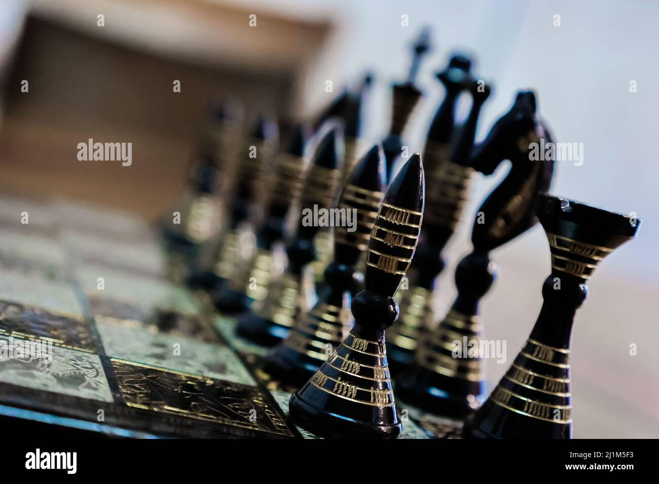 Scacchiera con pezzi di scacchi allineati con colori nero e oro. Foto Stock
