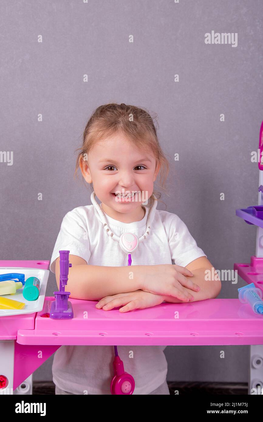 una bambina con uno stetoscopio giocattolo intorno al collo gioca medico  Foto stock - Alamy