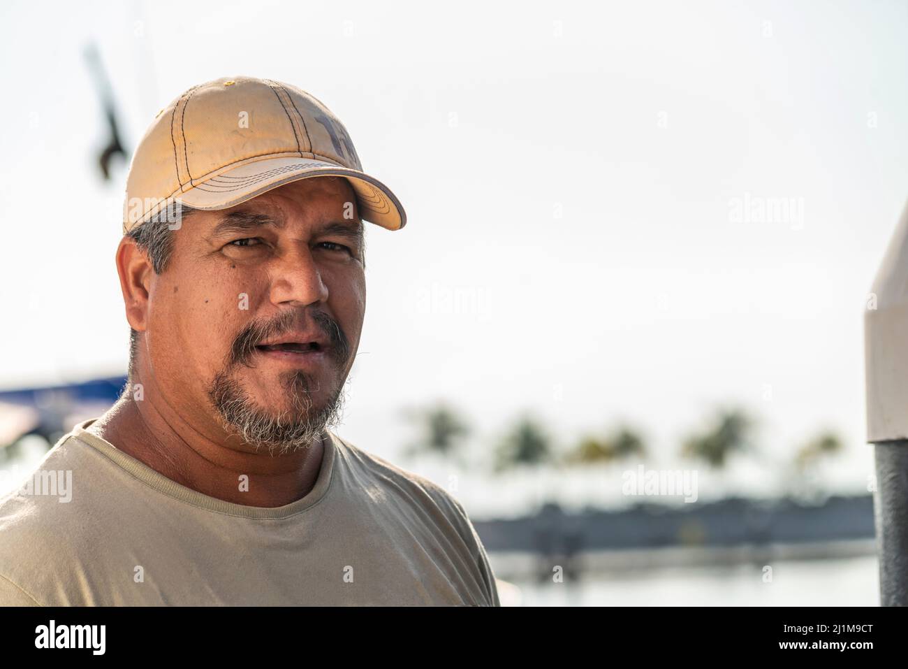 Ritratto di un pescatore latino maturo intervistato al molo Foto Stock