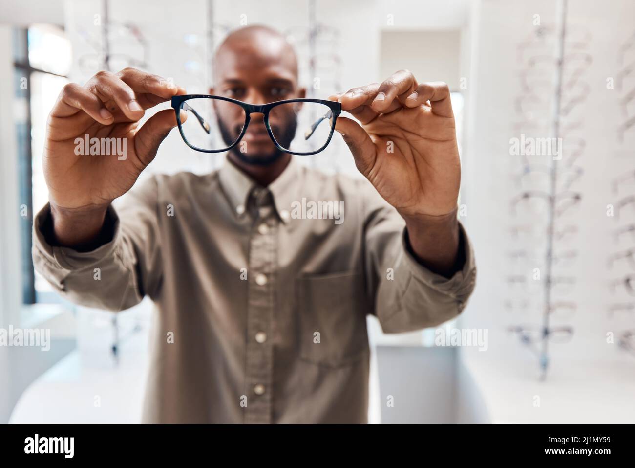 Vieni a trovarci per un'esperienza di apertura. Shot di una giovane donna che acquista un nuovo paio di occhiali in un negozio optometristo. Foto Stock