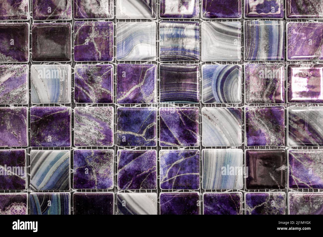 Sfondo viola astratto. Piccola piastrella verde e moderna in bagno. Struttura in vetroceramica. Parete in mosaico viola Foto Stock
