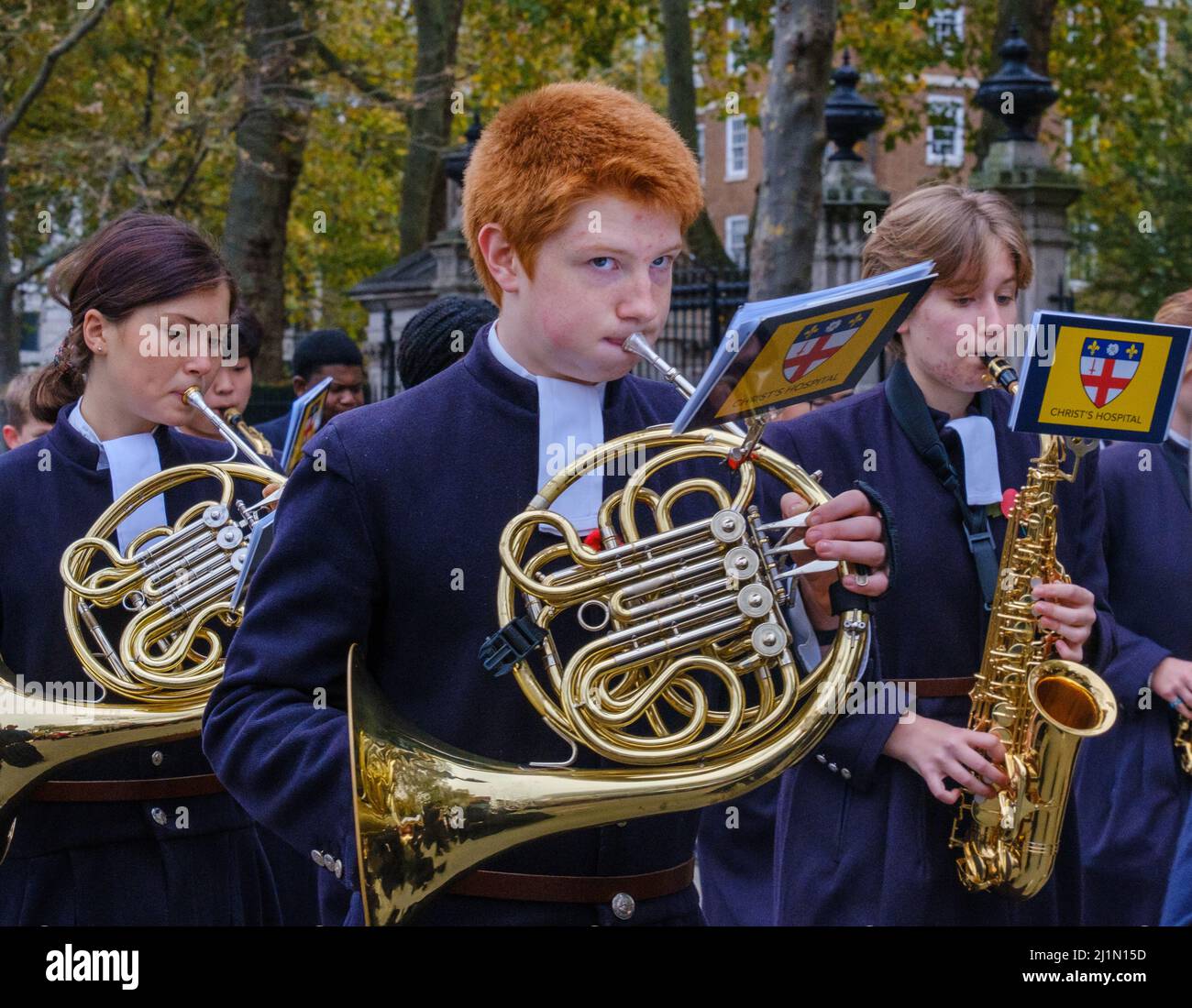 Primo piano di un ragazzo con pelo di zenzero che suona il corno francese con la Christ’s Hospital School Band nel Lord Mayor’s Show 2021, Victoria Embankment, Londra. Foto Stock