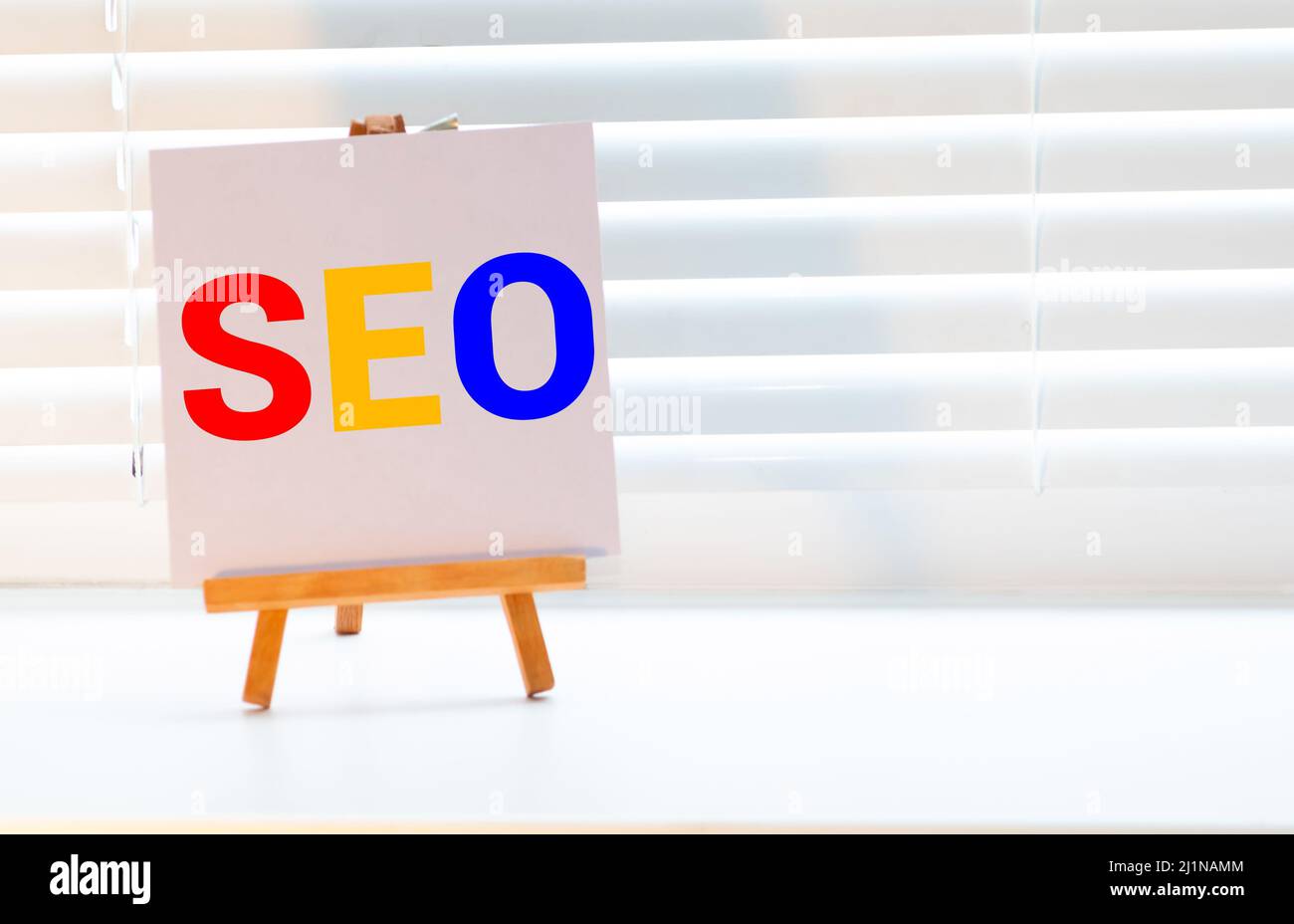 Su uno sfondo scuro, una pila di carte di registrazione luminose con le parole SEO Foto Stock