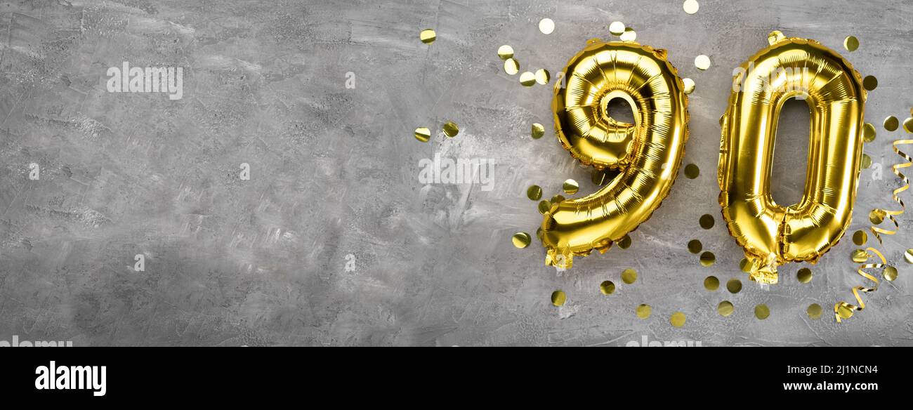 Numero palloncino in foglio giallo, numero novanta su sfondo concreto. Biglietto d'auguri con l'iscrizione 90. Concetto di anniversario. Per anniversario Foto Stock