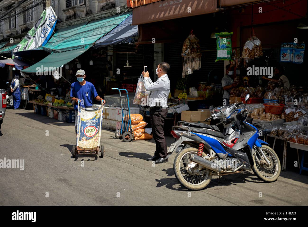 Fotografo smartphone. Uomo che scatta una fotografia in strada utilizzando una macchina fotografica del cellulare. Tailandia, Asia sudorientale Foto Stock