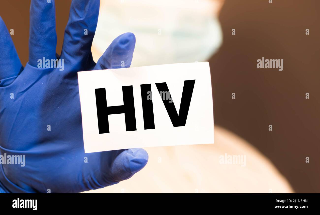 Lettere HIV o virus dell'immunodeficienza umana sulla scheda mostrata da un uomo Foto Stock