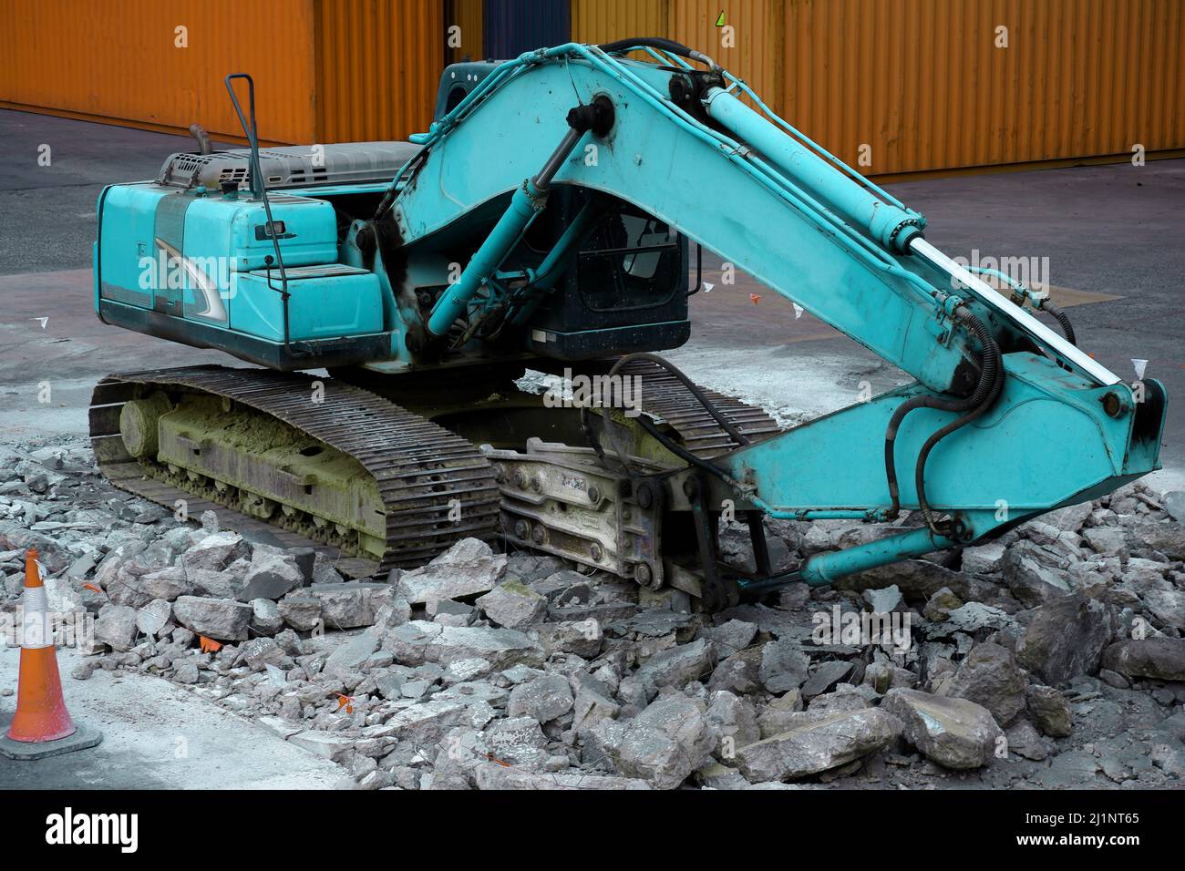 Escavatore da roccia in funzione per demolire il calcestruzzo. Foto Stock