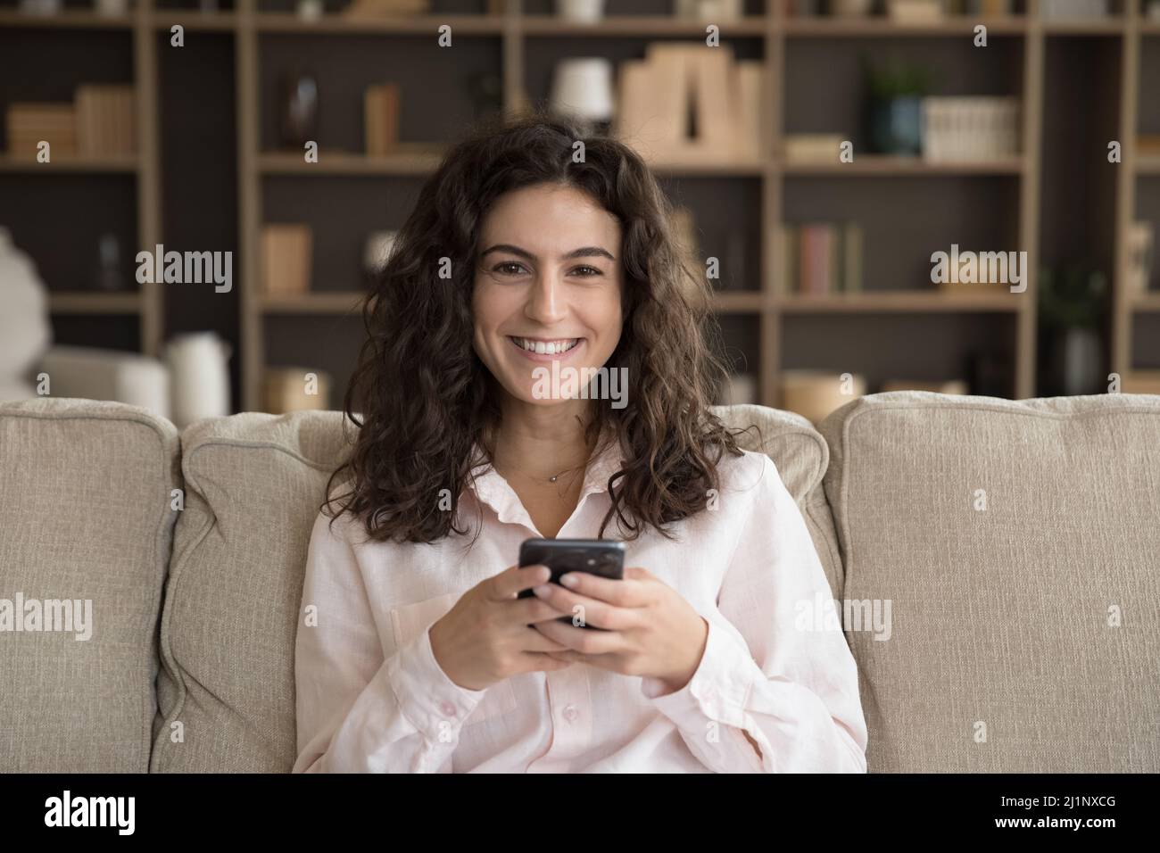 Felice utente allegro smartphone donna testa ripresa ritratto a casa Foto Stock