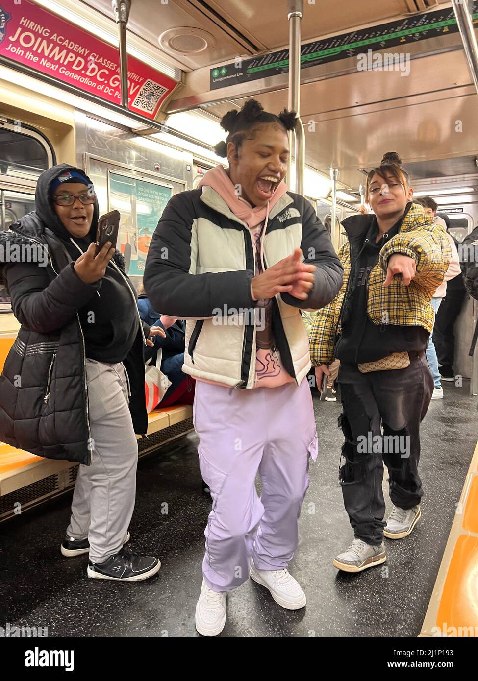 La giovane cantante e ballerina hip-hop si esibisce mentre i suoi amici la registrano mentre si guida un treno 6 lungo Lexington Avenue a Manhattan, New York City. Foto Stock