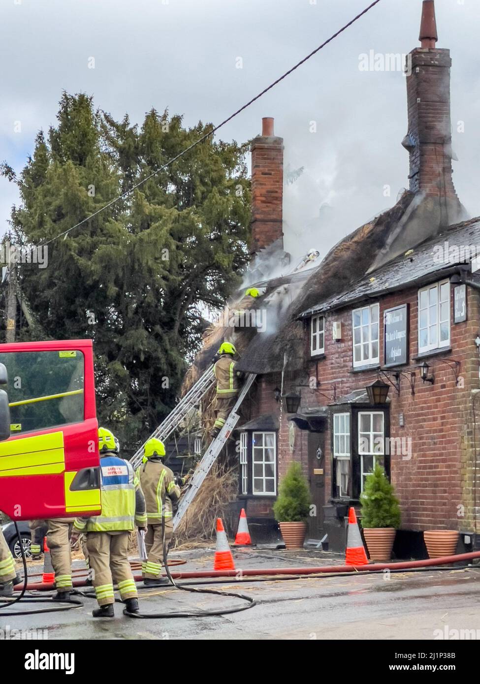 Zafferano Walden, Regno Unito. 27th Mar 2022. Fire oggi distrutto il famoso AX E BUSSOLA pub e ristorante a ARKESDEN, Saffron Walden. Essex. Il pub di paglia del 18th secolo, in essex ha preso il fuoco a mezzogiorno oggi proprio come il Christou si stava preparando per il loro giorno più trafficato dell'anno, con più di 150 prenotazioni per il pranzo del giorno delle madri. Essex vigili del fuoco e ambulanza hanno partecipato. Non sono state segnalate perdite. Molti ospiti abituali del pub all'epoca hanno aiutato a evacuare il personale e i mobili dai locali utilizzando una flotta di carriole. Credit: Mark Bourdillon/Alamy Live News Foto Stock