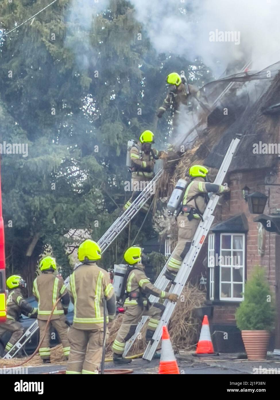 Zafferano Walden, Regno Unito. 27th Mar 2022. Fire oggi distrutto il famoso AX E BUSSOLA pub e ristorante a ARKESDEN, Saffron Walden. Essex. Il pub di paglia del 18th secolo, in essex ha preso il fuoco a mezzogiorno oggi proprio come il Christou si stava preparando per il loro giorno più trafficato dell'anno, con più di 150 prenotazioni per il pranzo del giorno delle madri. Essex vigili del fuoco e ambulanza hanno partecipato. Non sono state segnalate perdite. Molti ospiti abituali del pub all'epoca hanno aiutato a evacuare il personale e i mobili dai locali utilizzando una flotta di carriole. Credit: Mark Bourdillon/Alamy Live News Foto Stock