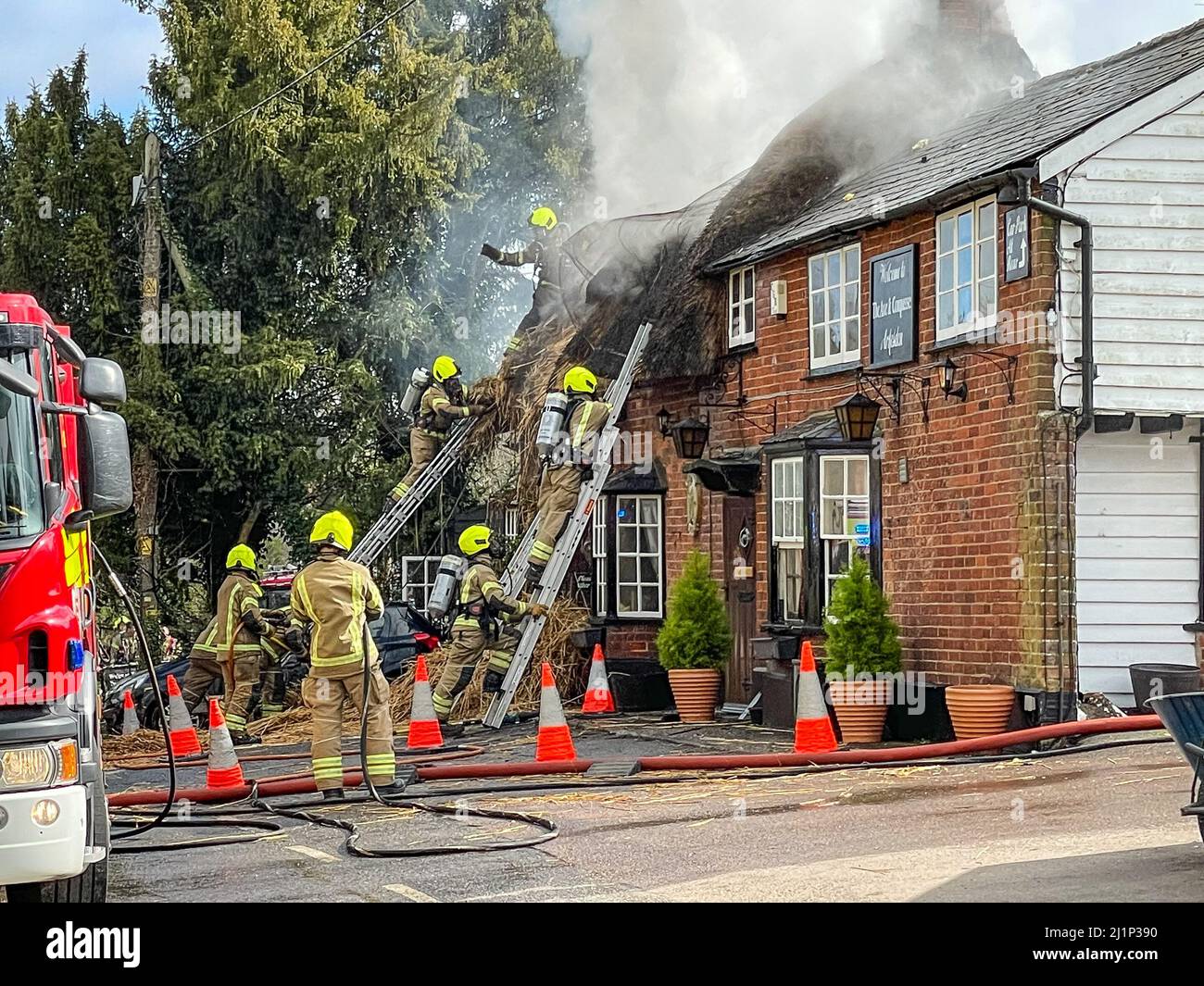 Zafferano Walden, Regno Unito. 27th Mar 2022. Fire oggi distrutto il famoso AX E BUSSOLA pub e ristorante a ARKESDEN, Saffron Walden. Essex. Il pub di paglia del 18th secolo, in essex ha preso il fuoco a mezzogiorno oggi proprio come il Christou si stava preparando per il loro giorno più trafficato dell'anno, con più di 150 prenotazioni per il pranzo del giorno delle madri. Essex vigili del fuoco e ambulanza hanno partecipato. Non sono state segnalate perdite. Molti ospiti abituali del pub all'epoca hanno aiutato a evacuare il personale e i mobili dai locali utilizzando una flotta di carriole. Credit: Mark Bourdillon/Alamy Live News Foto Stock
