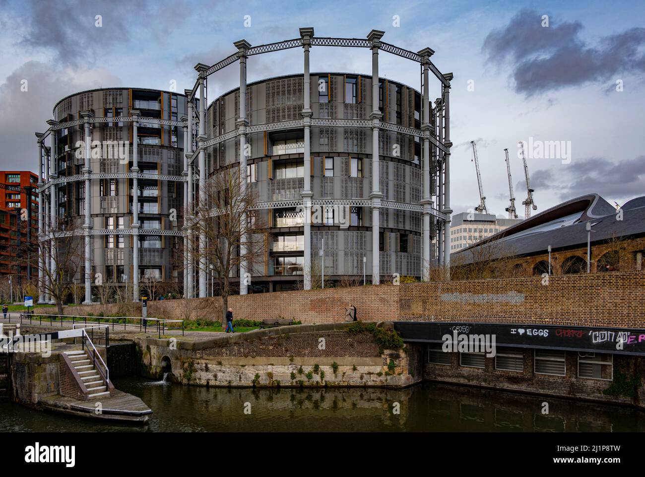 I Gasholders si sono risviluppati nell'area di King's Cross come visto dal Regent's Canal di Londra Foto Stock