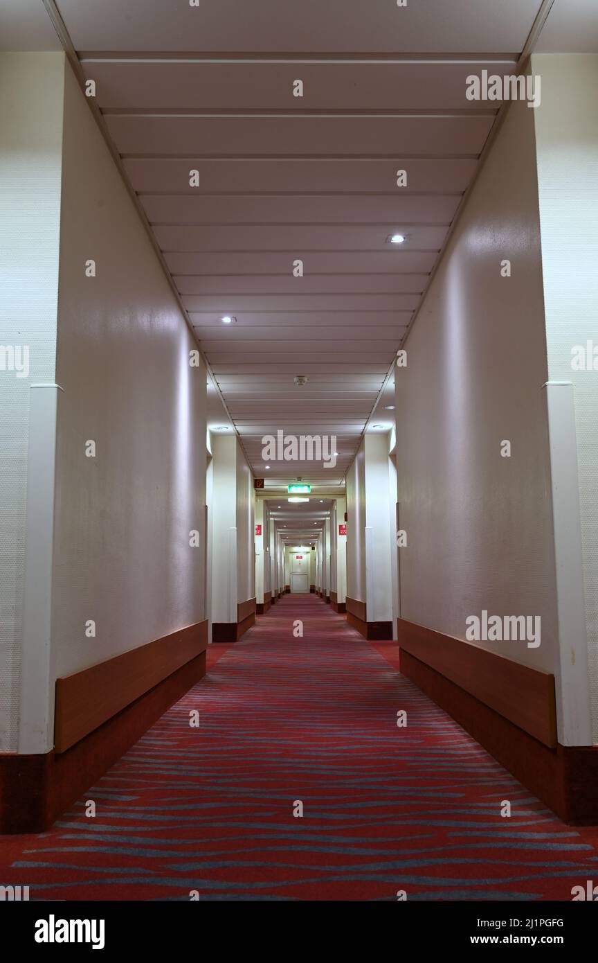 Lungo corridoio dell'hotel con pavimento in moquette rossa Foto Stock