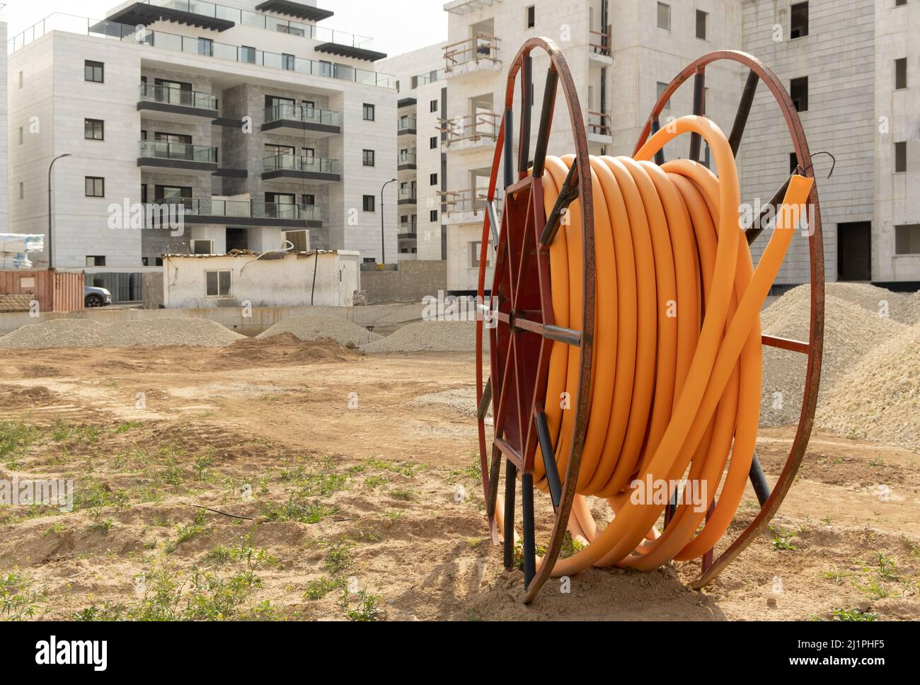 Proteggere i cavi negli impianti elettrici, sviluppo delle comunicazioni, bobine grandi di tubo PVC arancione tubo in plastica tubo pvc su costruzione si Foto Stock