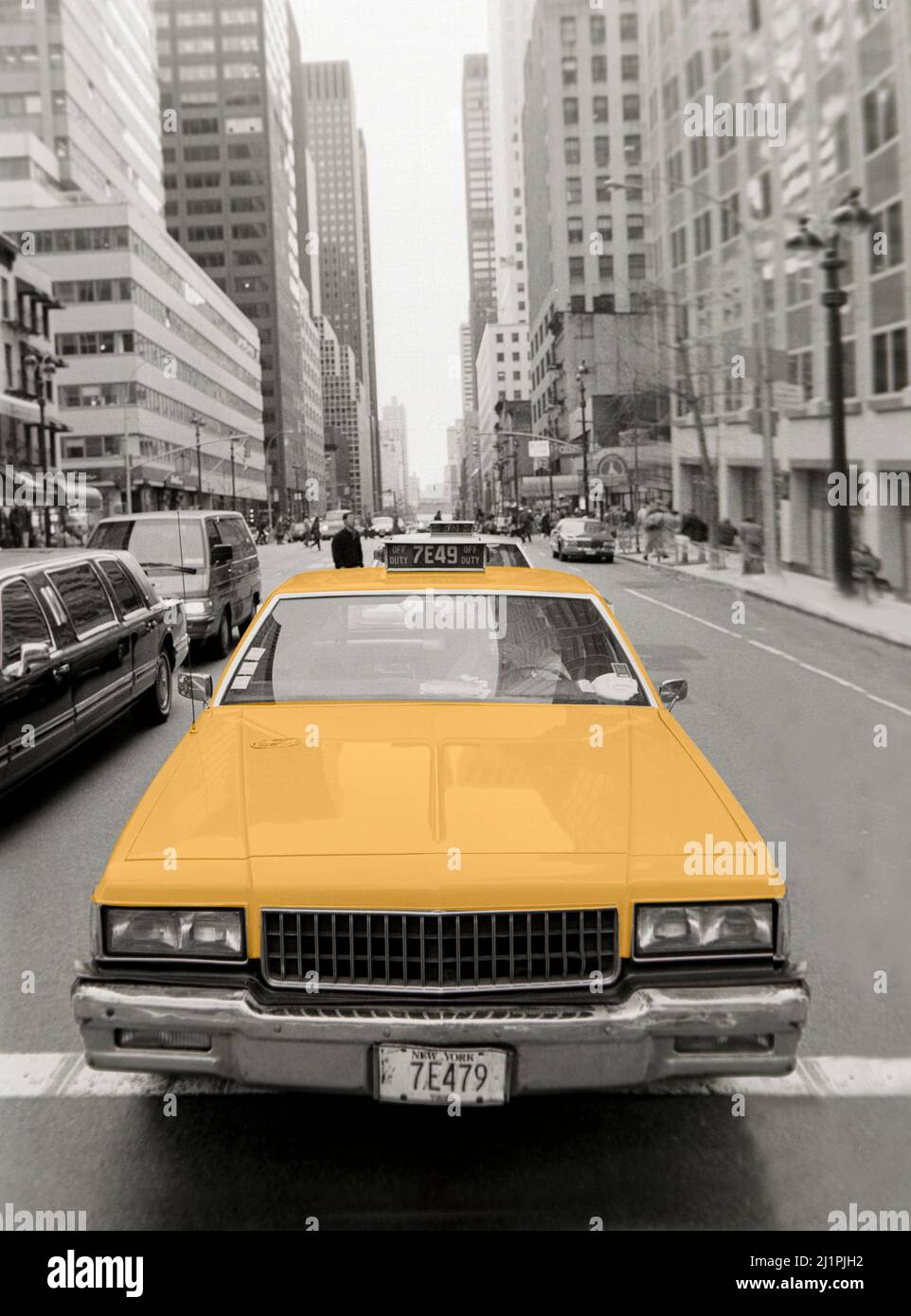 Un taxi Yellow Cab per le strade di New York. Foto in bianco e nero con cabina colorata. I numeri sulle targhe vengono modificati. Foto Stock