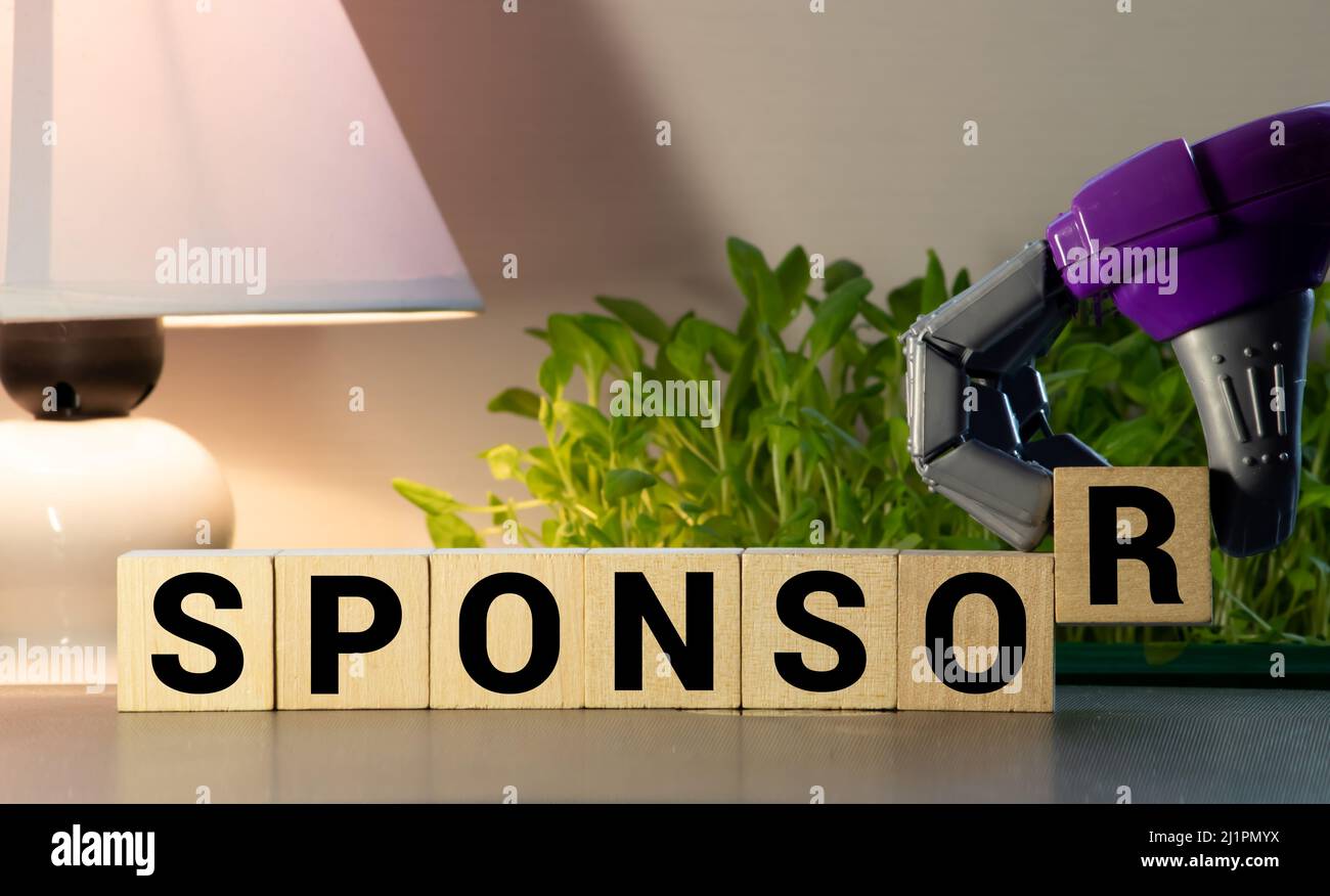 La parola DI SPONSOR sul concetto di piastrelle in legno. Foto Stock