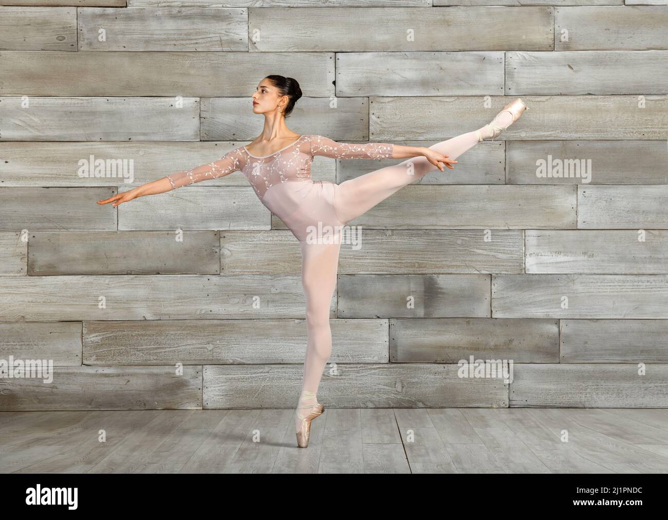Corpo completo di ballerina classica femminile che si bilancia su tipoes in scarpe a punta durante le prove in studio di danza Foto Stock