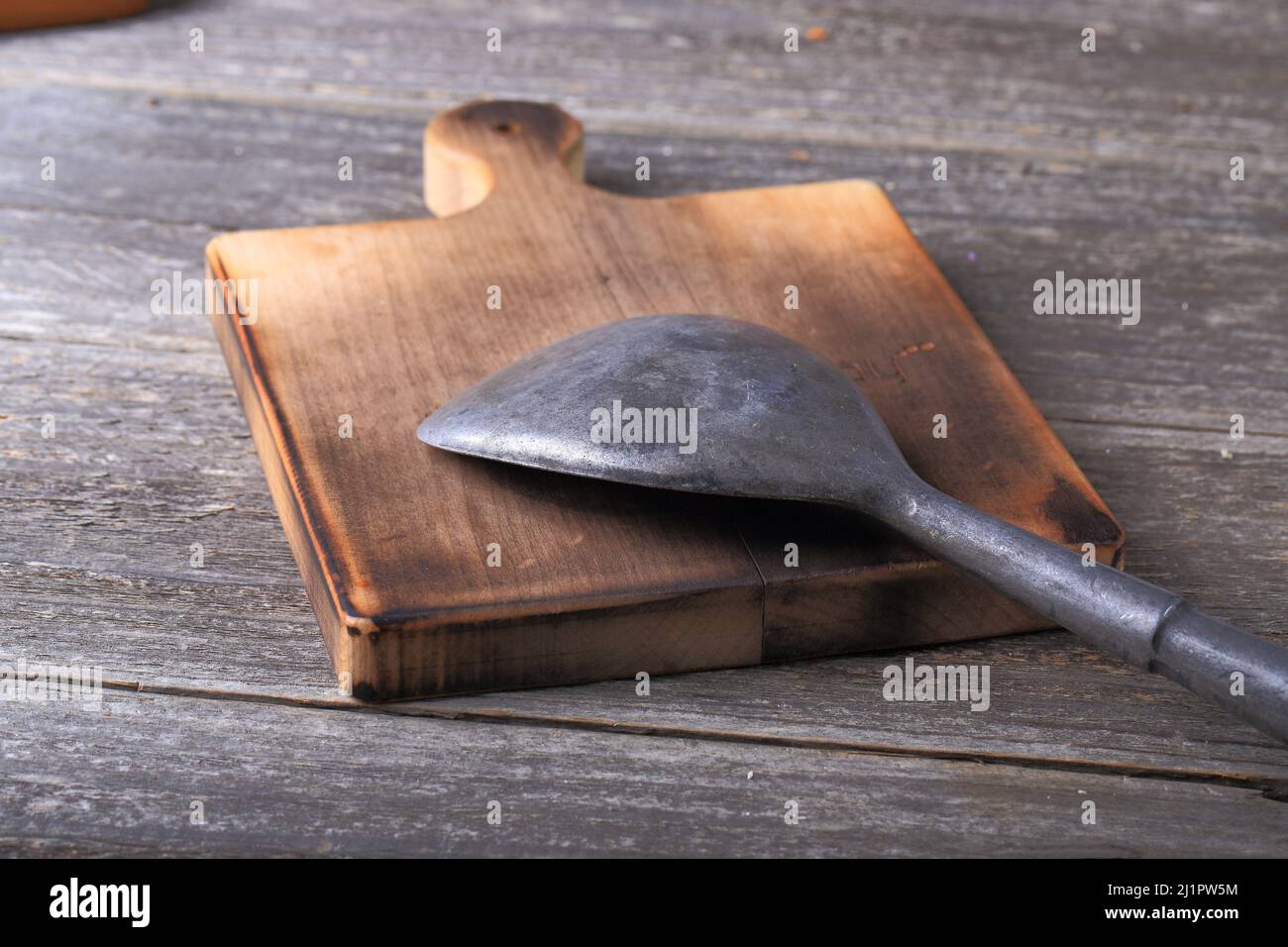 Utensile da cucina in metallo su tagliere in legno Foto Stock
