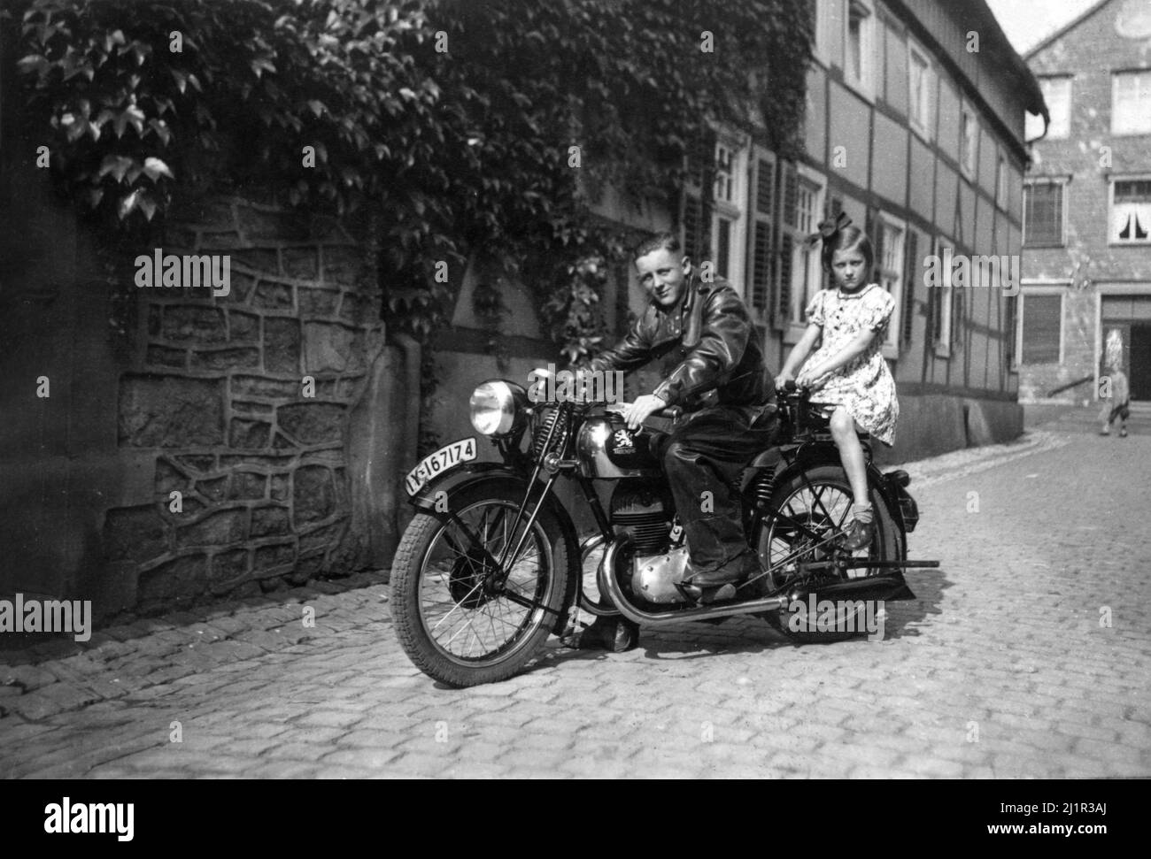 Giovane uomo e giovane ragazza su Triumph Motorcycle. Immagine vintage dalla Germania nel 1940s Foto Stock