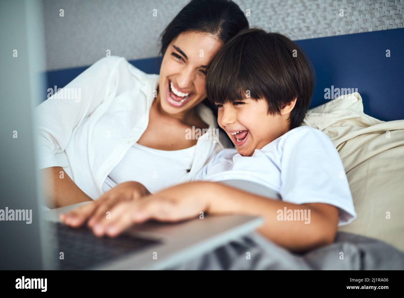 Theres così tanto intrattenimento da essere trovato in linea. Scatto di una madre e di suo figlio utilizzando un computer portatile insieme a casa. Foto Stock